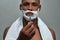 Portrait of handsome young african american man with shaving foam applied on his face looking at camera, holding steel