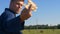 Portrait of a handsome young farmer student sitting on haystack, beautiful smile, in work clothes with airplane in hand. Concept