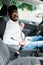 Portrait of handsome young indian man sitting in driving seat of car and wearing seatbelt for safety