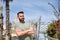 Portrait of handsome young man with blue eyes, beard and green t-shirt with crossed arms and distracted gesture. Concept beauty,