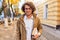 Portrait of handsome young man with books outdoors. College male student carrying books in college campus in autumn street