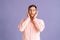 Portrait of handsome young man covering ears with hands do not wanna listen standing on pink  background in