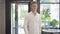 Portrait of handsome young man entering cafe and making order. Cheerful confident Caucasian guy in white shirt and jeans