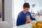 Portrait of handsome young man pours tea with cat on the kitchen.