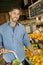 Portrait of handsome young man shopping for fruits in market