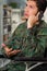 Portrait of a handsome young soldier sitting on wheel chair using his cellphone, in a blurred background