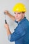 Portrait of handyman hammering nail in wall