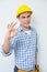 Portrait of a handyman in yellow hard hat gesturing okay sign