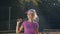 Portrait of hansome woman with tennis racket in the tennis uniform walking outdoor.