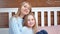 Portrait of happiness mother and cute daughter posing and looking at camera at home interior