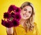 Portrait, happiness and woman giving flowers in studio isolated on a yellow background. Floral, bouquet present and