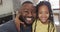 Portrait of happy african american daughter and father taking selfie on sofa