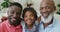 Portrait of happy african american grandfather with adult son and granddaughter