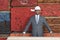 Portrait of happy African American male contractor standing in front of stacked wooden planks