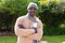 Portrait of happy african american man standing in garden wearing woolly hat and scarf