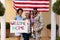 Portrait of happy african american soldier celebrating soldier\\\'s return with placard at entrance