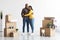 Portrait Of Happy African American Spouses Standing Among Cardboard Boxes After Moving