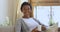 Portrait of happy african woman relaxing at home drinking coffee