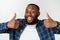 Portrait of happy afroamerican handsome bearded man laughing and showing thumb up gesture.