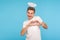 Portrait of happy angelic man with halo above head making heart shape with hands and smiling to camera