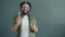 Portrait of happy Arab guy dancing enjoying music on gray color background