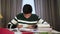 Portrait of happy Asian boy studying indoors. Cute teenage college student sitting at the table with books and smiling