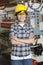 Portrait of happy Asian female industrial worker with machinery in background