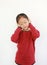 Portrait of happy Asian little child placing hands on ears. Joyful kid closed eyes and smiling on white isolated background