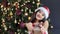 Portrait of happy Asian woman wearing Santa Claus hat and suit smiling and gives present in gift box
