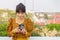 Portrait happy Asian woman wearing a yellow Thai patterned dress watching her cell phone in her hands with blank for copy space