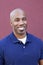 Portrait of a happy bald African American male over colored background