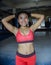 Portrait of happy beautiful and sweaty young Asian woman in sport training cloths smiling relaxed at gym