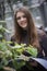 Portrait of happy beautiful young science student. Young girl in a greenhouse with tropic plants