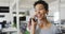 Portrait of happy biracial businesswoman making call in office