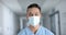 Portrait of happy biracial male doctor wearing face mask, slow motion