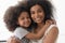 Portrait of happy biracial mom and daughter hugging