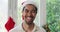 Portrait of happy biracial young man in santa hat at home during christmas