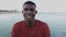 Portrait happy black american man looking at camera by the sea