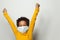 Portrait of happy black child boy in medical protective face mask holding hands up