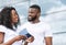 Portrait of happy black couple with passports and tickets in hands