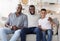 Portrait of happy black multigenerational men family posing on couch at home