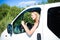 Portrait of happy blond woman driving white car