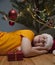 Portrait of happy boy sleep under Christmas tree