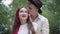 Portrait of happy boyfriend kissing smiling girlfriend on head outdoors. Young loving Caucasian couple standing in