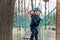 Portrait happy brave courage little toddler child boy wear safety equipment helmet enjoy passing obstacle course forest