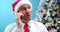 Portrait of happy business man calling phone indoor. Closeup smiling man in Christmas Hat Santa Clausa talking mobile