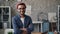 Portrait of happy business owner standing in office with arms crossed smiling