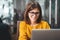 Portrait of happy business woman wearing glasses at workplace in office