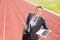 Portrait of happy businesswoman ready to run with a laptop and briefcase