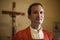 Portrait of happy catholic priest smiling at camera in church